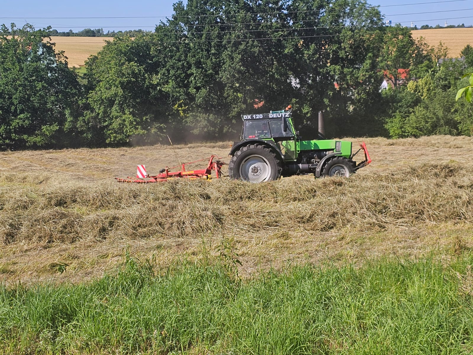 Deutz DX 120 Traktor mit Heuwender auf dem Feld